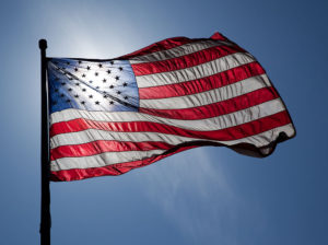 United States Flag, backlit on a windy day.